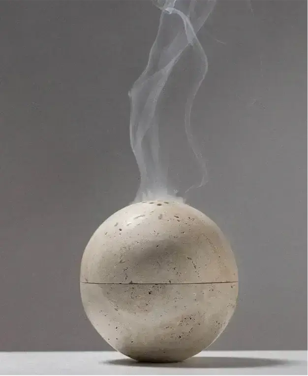 Handcrafted marble incense burner emitting smoke, showcasing elegant design for rituals and relaxation.