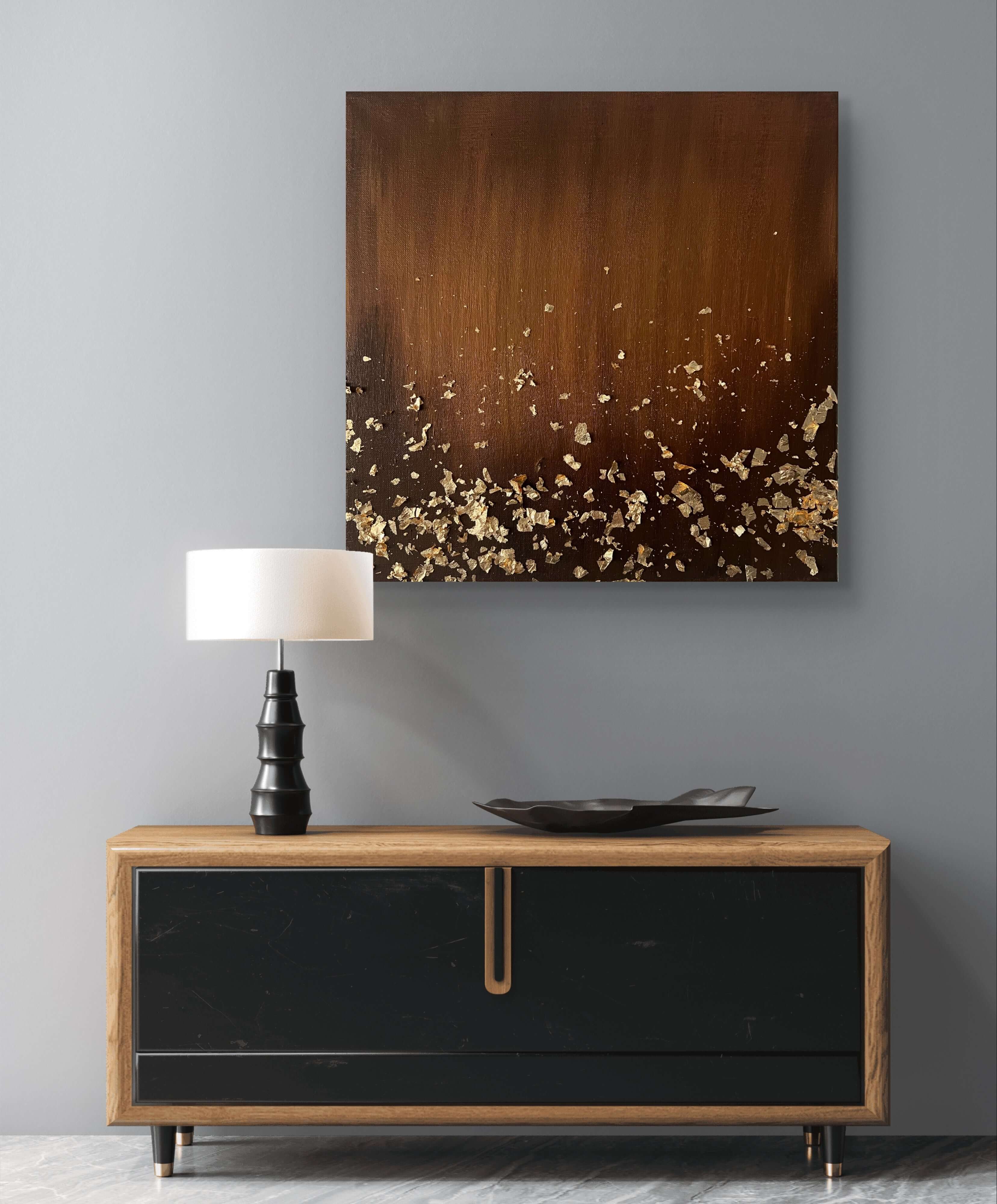 Handmade acrylic painting 'Mocha Glow' with gold leaf on a wall above a modern sideboard and lamp, featuring warm brown tones.