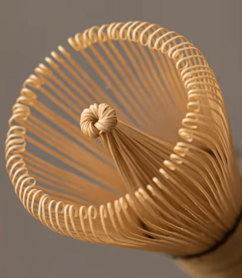 Close-up of a traditional Japanese bamboo matcha whisk (chasen) used in tea ceremonies.