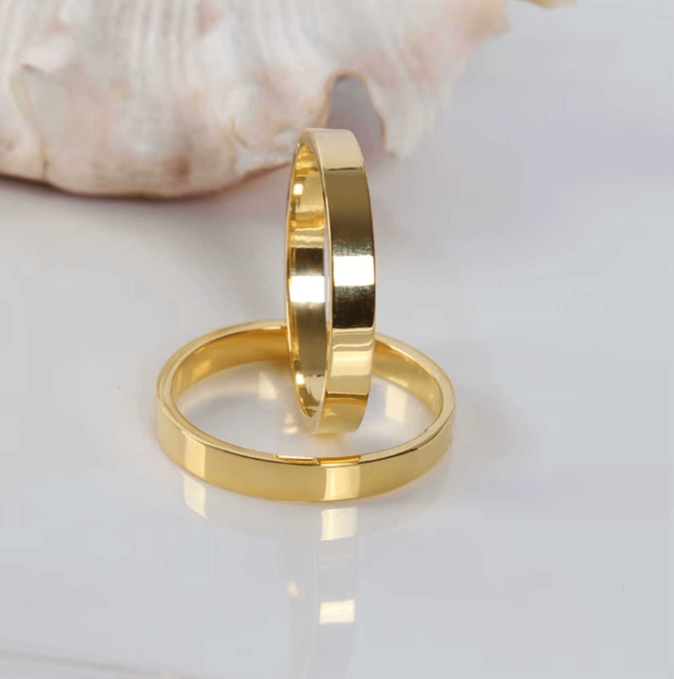 Elegante goldene Serviettenringe auf weißem Hintergrund