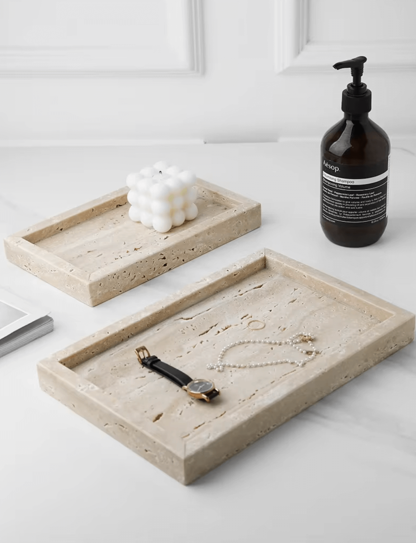 Minimalist marble tray set made from travertine, showcasing jewelry and a bottle, adding elegance to everyday organization.