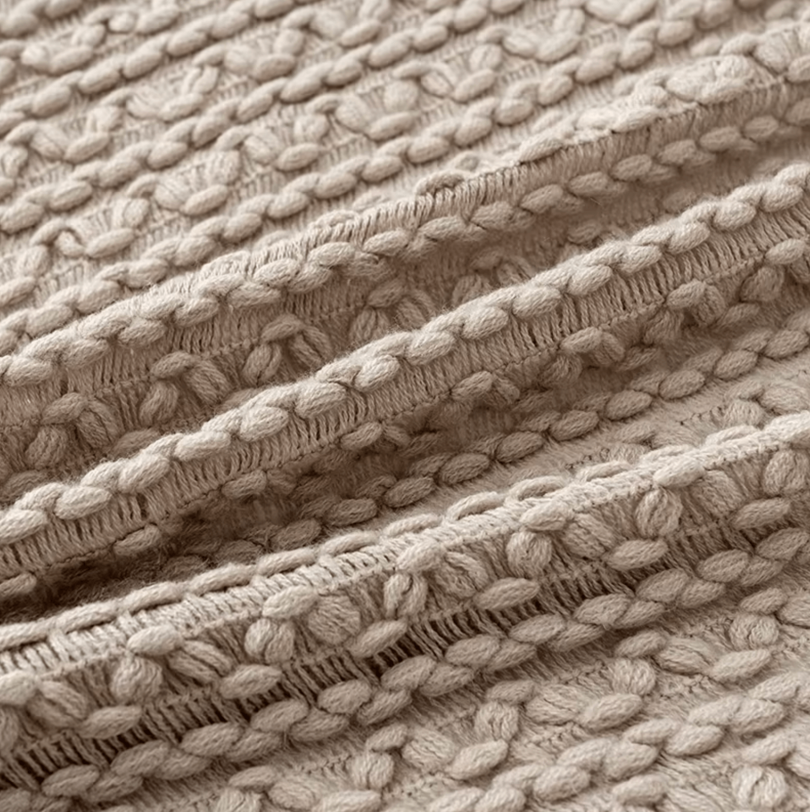 Close-up of beige boho knitted throw with intricate tassel detailing, showcasing vintage charm and luxurious texture.