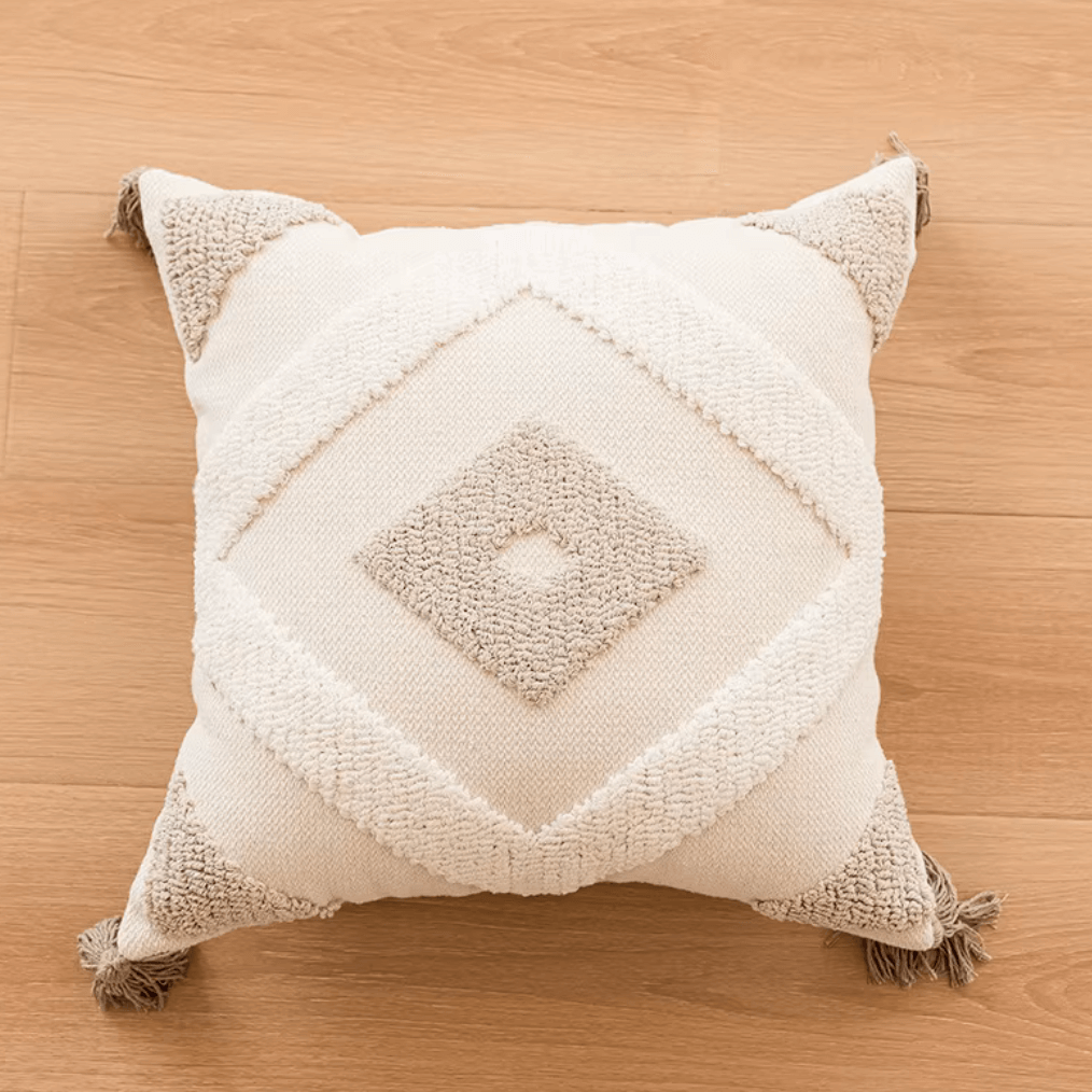 Boho Kissenbezug mit Diamantmuster und Quasten in Beige auf Holzboden, handgefertigt aus 100 % Baumwolle für gemütliches Wohndesign.