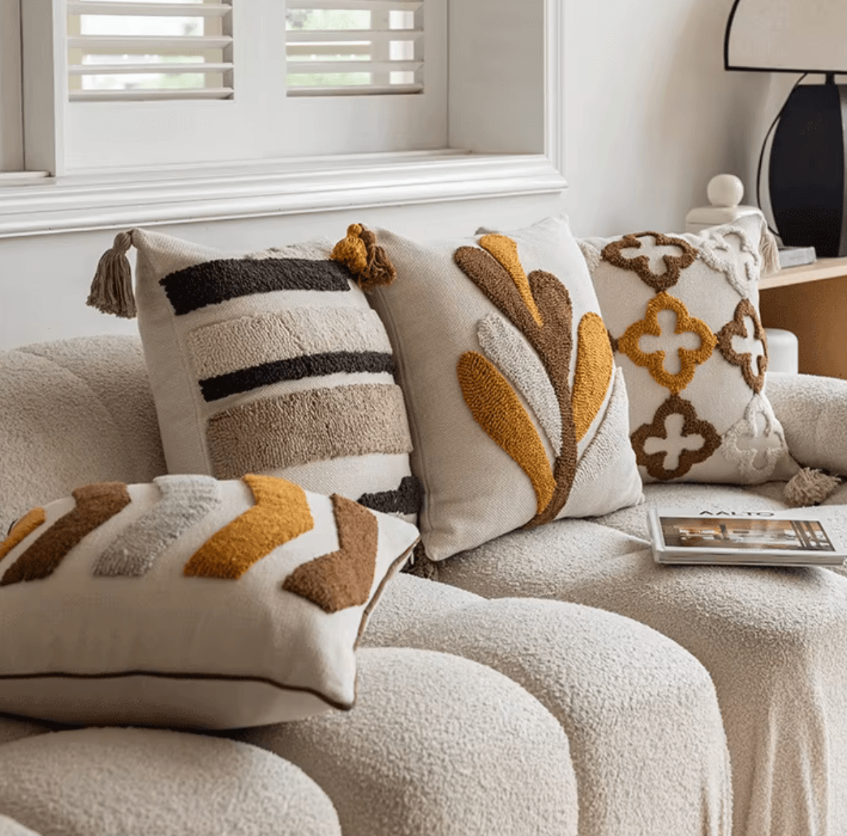 Nordic Retro Kissenbezug mit geometrischem Tufting-Muster in warmen Gelb- und Brauntönen auf einem gemütlichen Sofa.