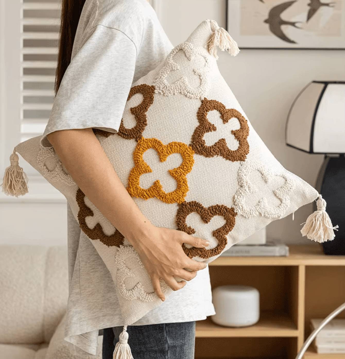 Person holding a Nordic Retro Kissenbezug with geometric tufting in warm yellow-brown tones; adds cozy Scandinavian charm to any room.