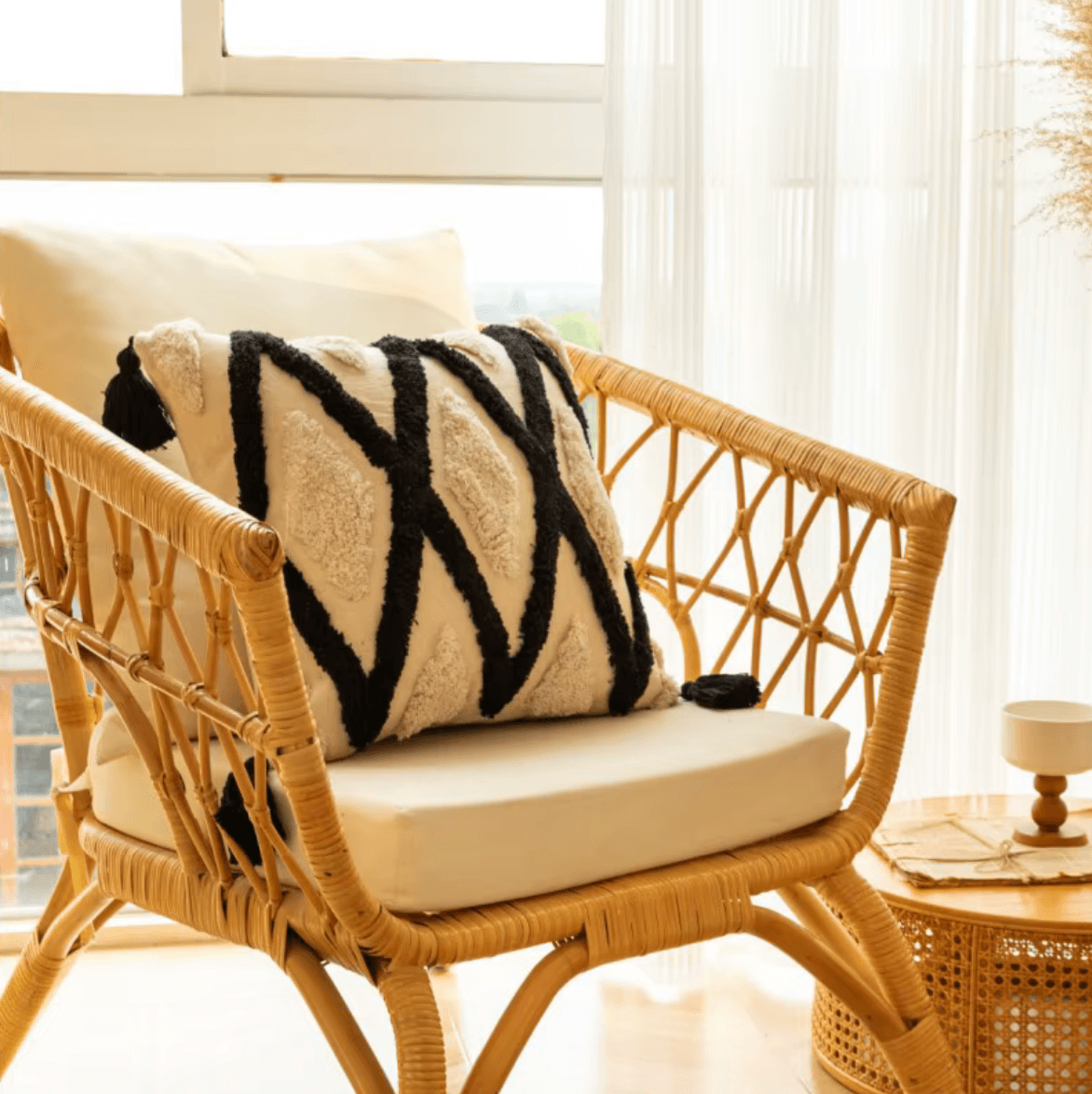 Boho Kissenbezug mit geometrischem Gitter-Design auf modernem Rattanstuhl im gemütlichen Raum