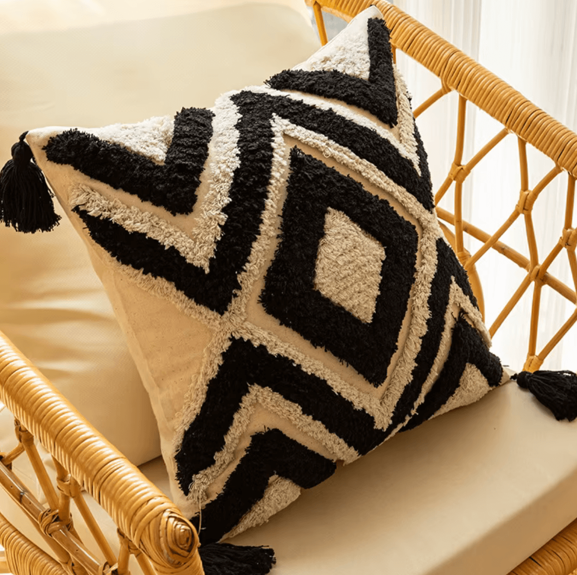 Boho Kissenbezug with black and white geometric grid design on a rattan chair, perfect for modern home decor.
