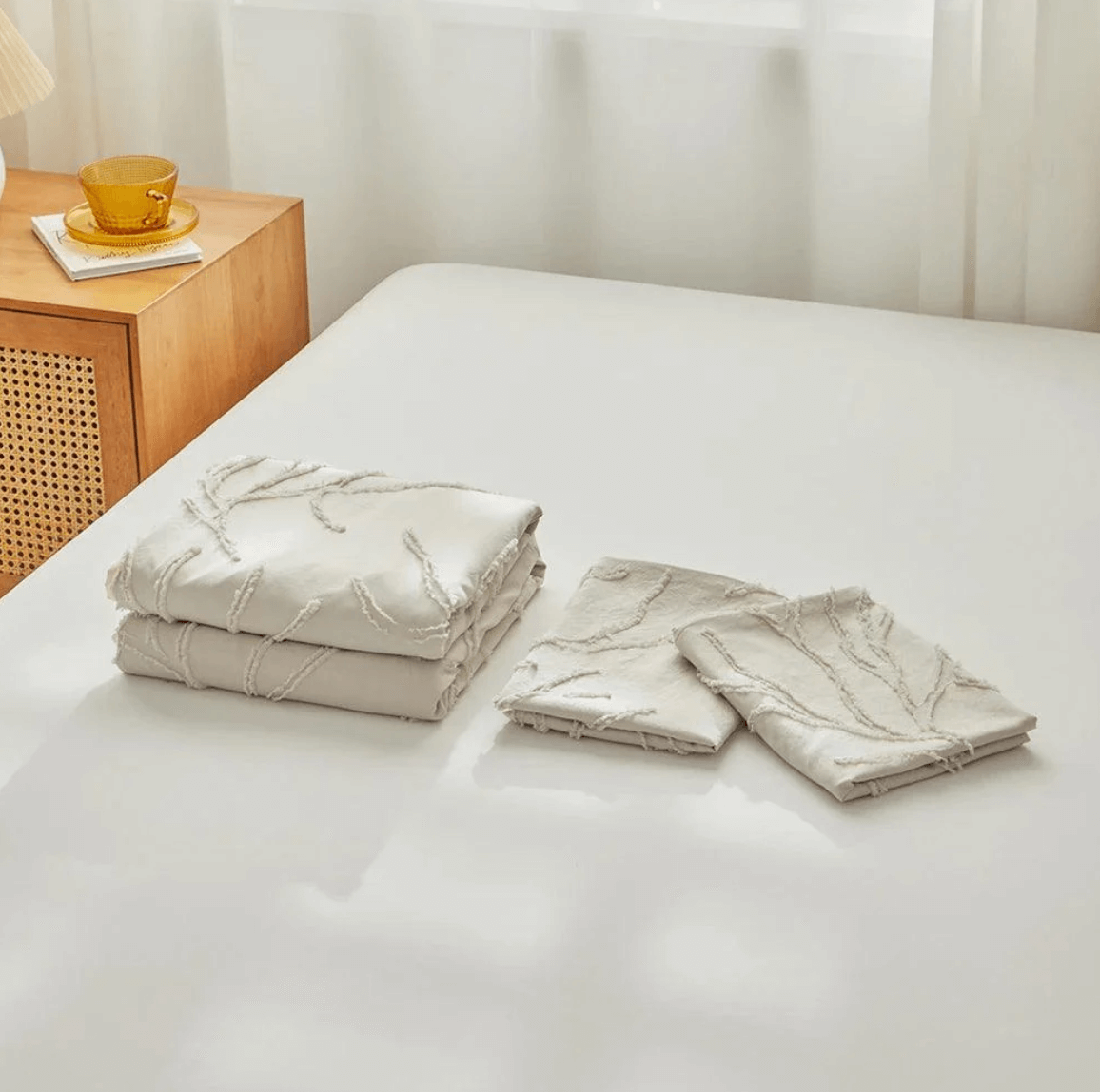 Tufted Bettwäsche-Set in Beige with Boho-Chic Baumzweig Design displayed on a bed next to a wooden nightstand with a mug.