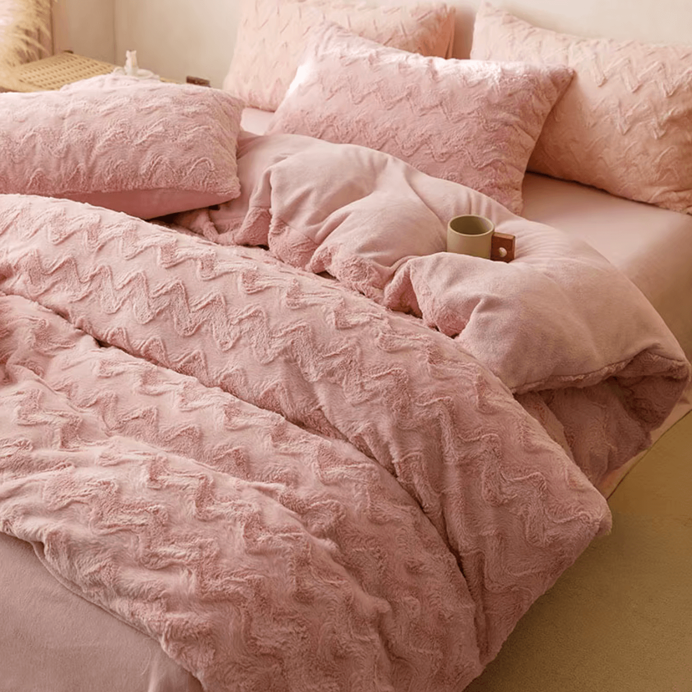 Luxurious pink cashmere bedding set with zig-zag design on a bed, featuring plush texture for a cozy and stylish bedroom setup.