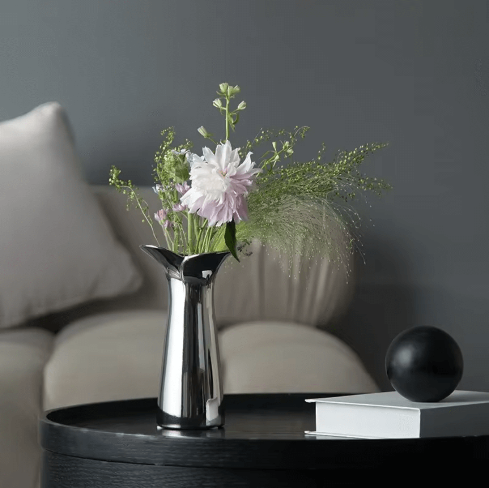 Silver-finish glass vase with flowers on a table, Nordic luxury decor for living spaces.