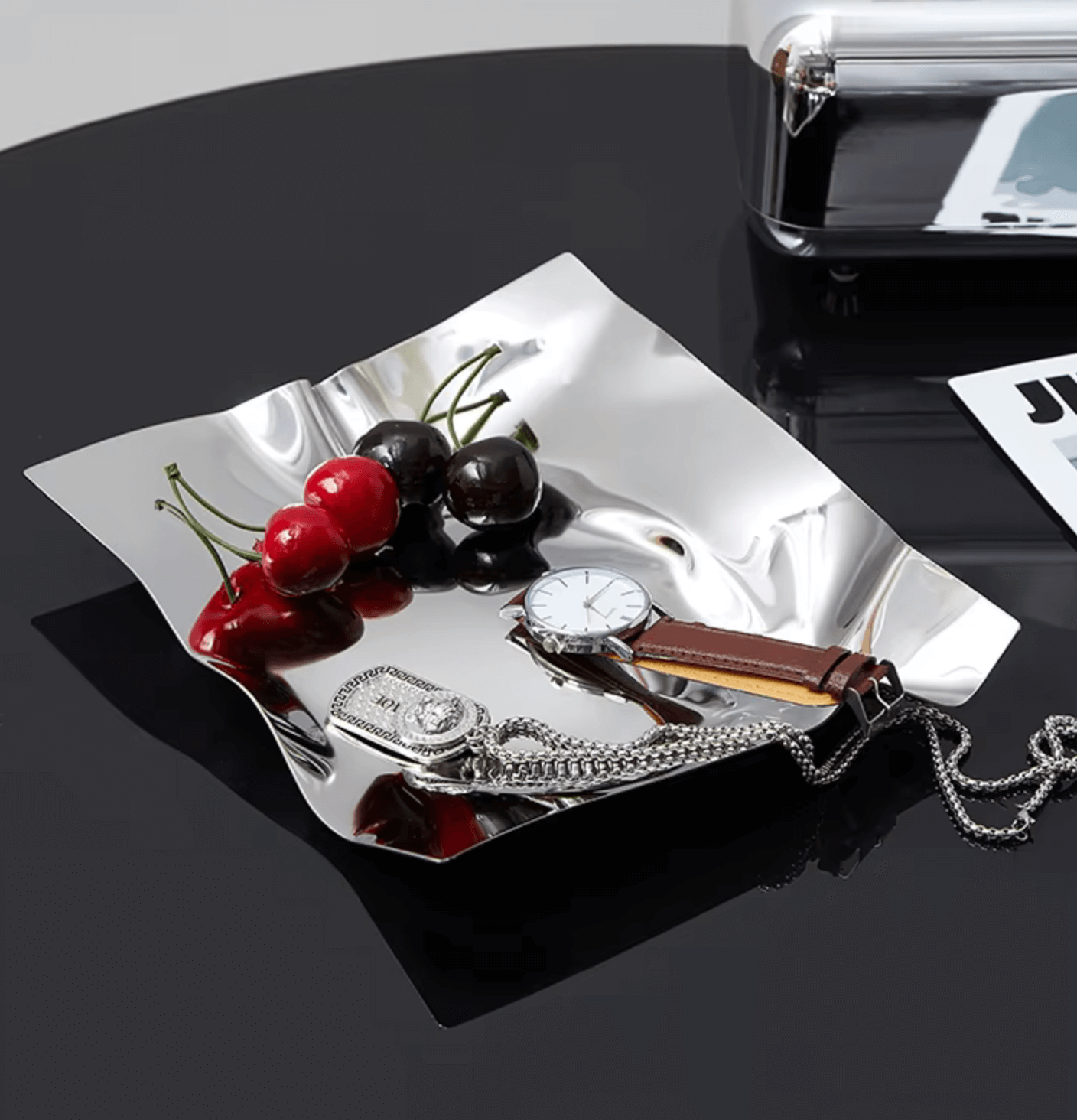 Edelstahl-Tablet mit Uhr, Schmuck und Kirschen, vielseitig als Schmuckablage oder Obstplatte, modernes Wohnaccessoire aus hochwertigem Edelstahl.