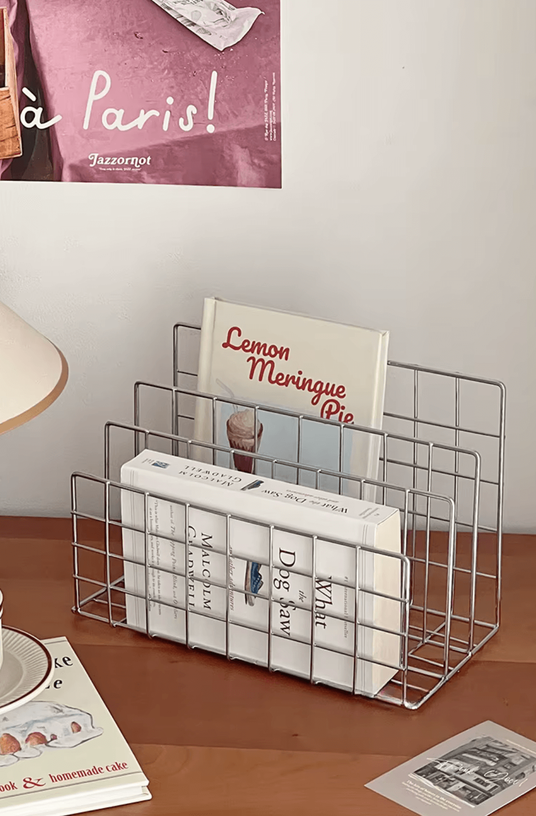 Stylish iron document organizer on desk with books and magazines, modern minimalist design for a neat workspace.