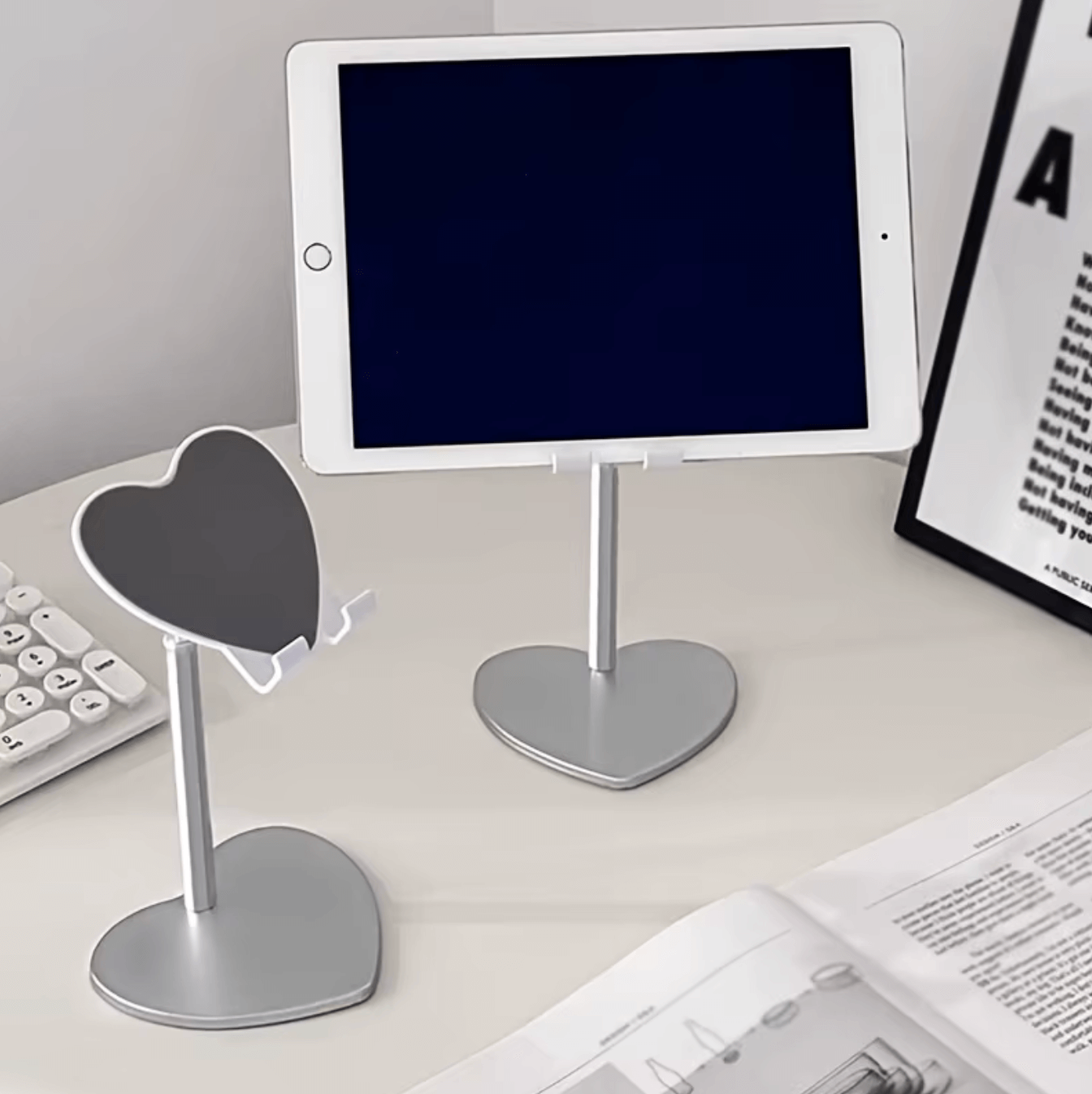 Heart-shaped adjustable brackets holding a tablet on a desk, ideal for hands-free video watching and video calls.