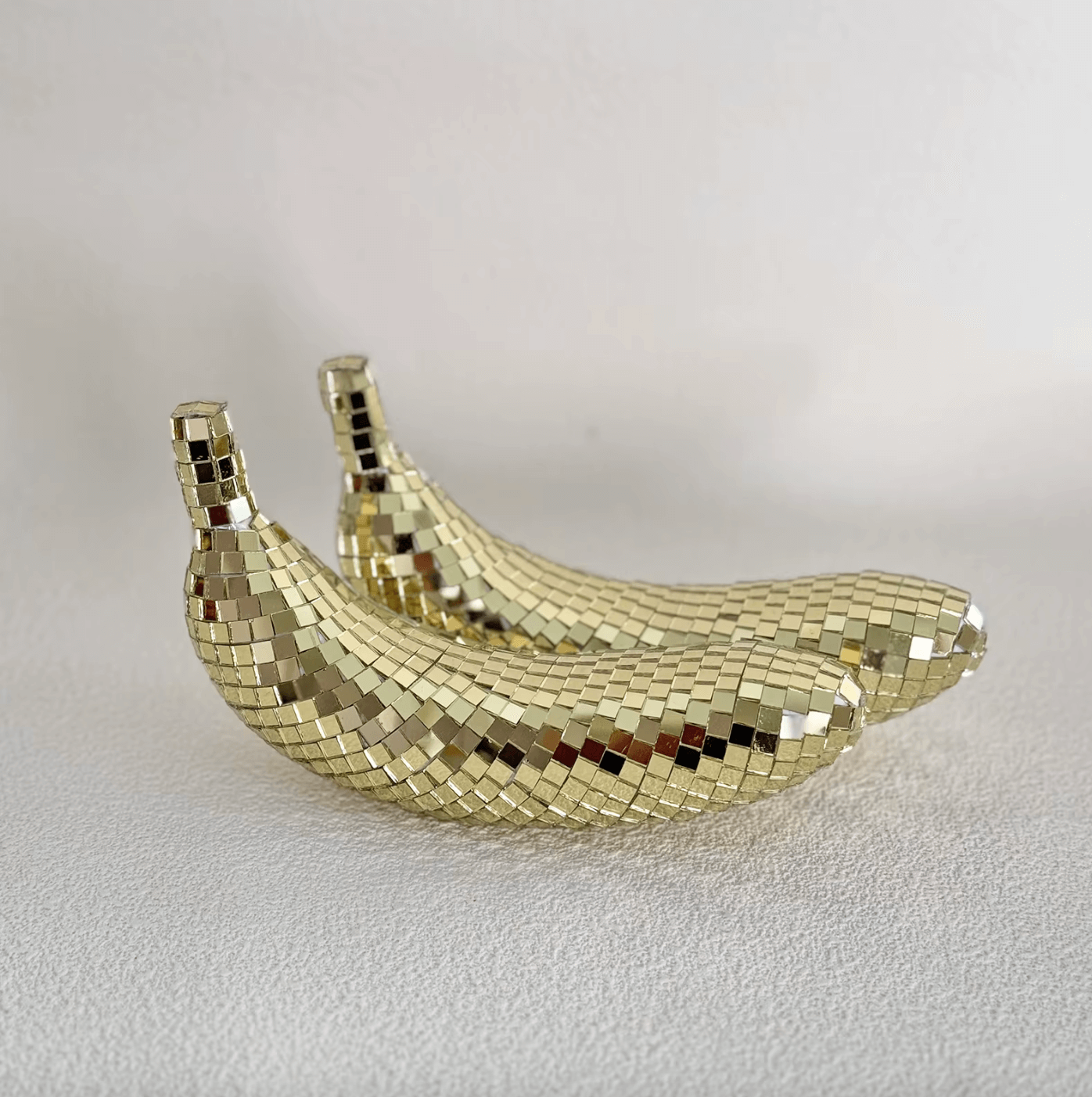 Reflective disco banana decor set, featuring two shimmering banana sculptures with mirror tiles, perfect for adding glamour to home spaces.