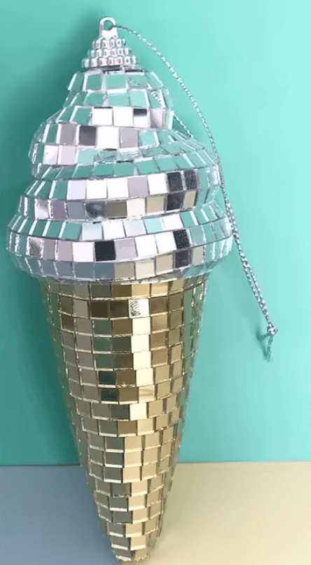 Disco-Eis Hängedekoration mit funkelnden Spiegelornamenten, im Retro-Design, auf türkisem Hintergrund, beleuchtet für zauberhafte Reflexionen.