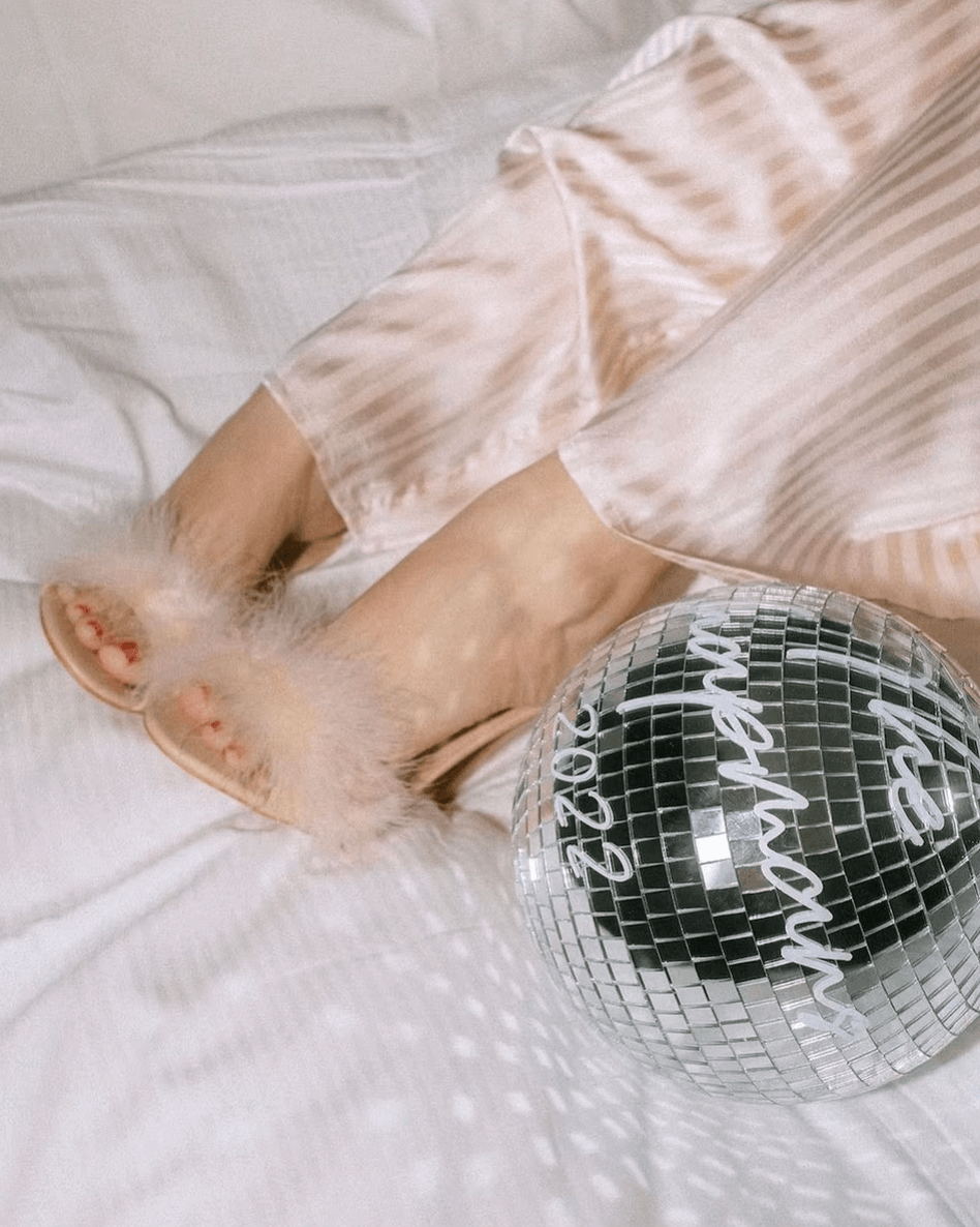 Cozy setting with personalized disco ball next to fluffy slippers, creating a stylish and fun ambiance.