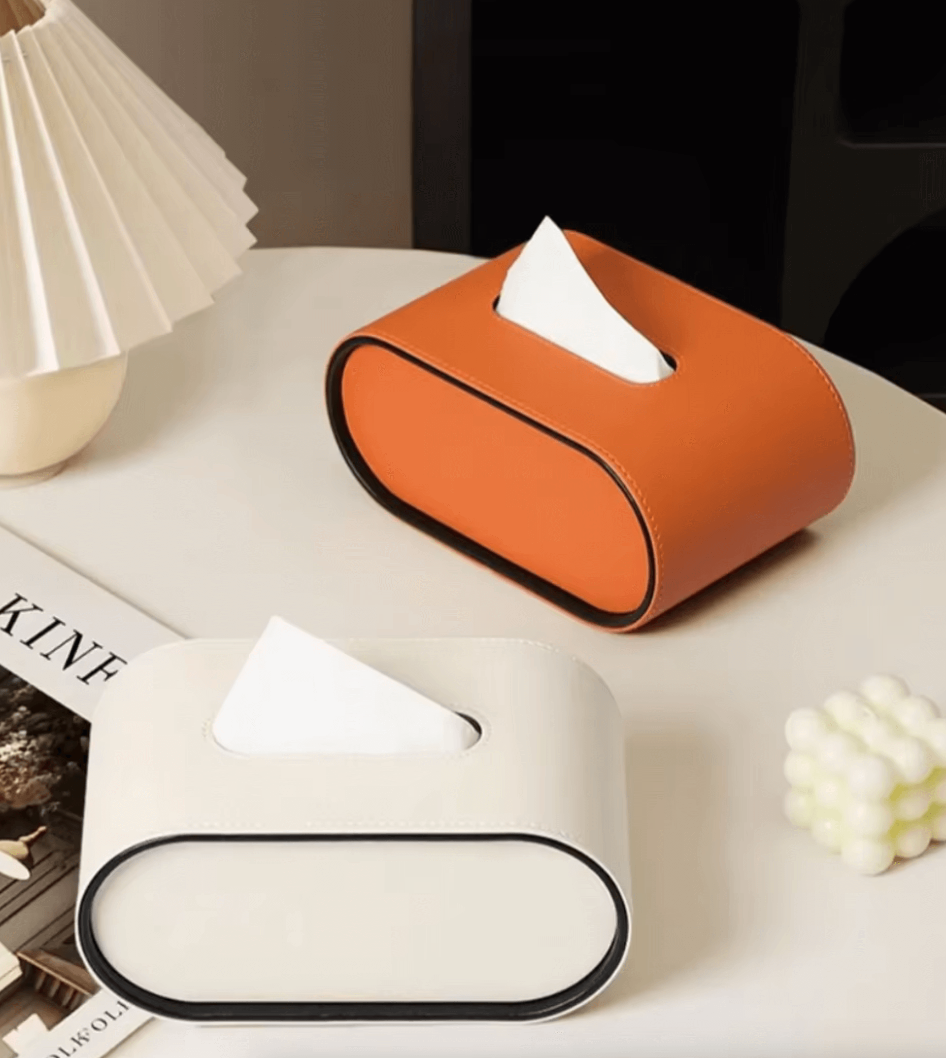 Elegant oval leather tissue boxes in white and orange for stylish home or car decor.