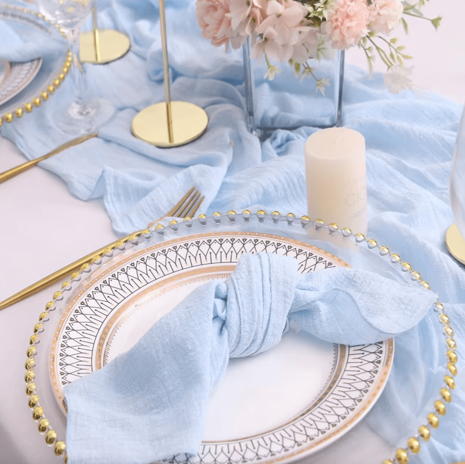 Elegant table setting with blue cotton napkins and floral centerpiece.