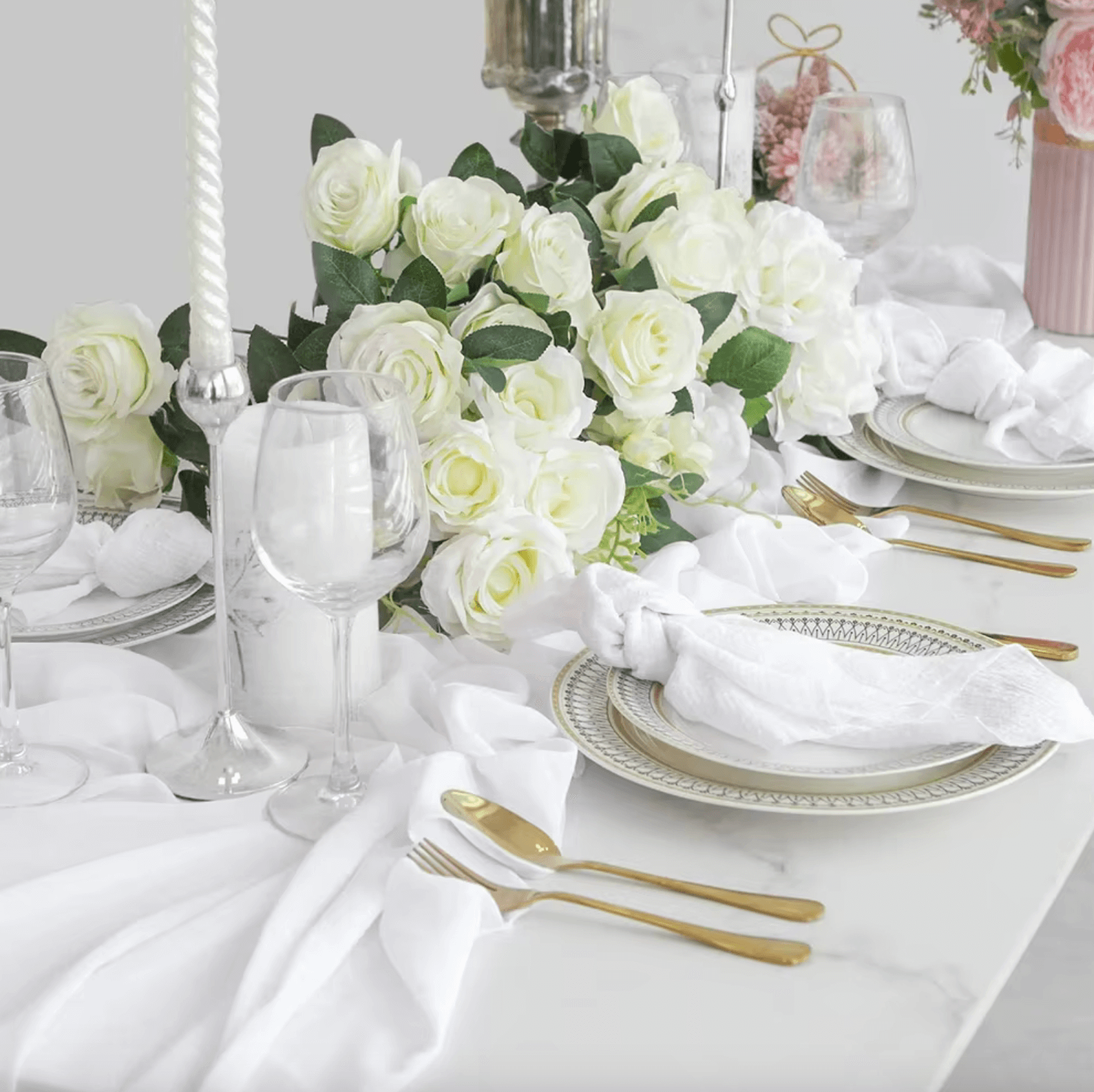 Elegant table setting with cotton napkins, white roses, and silverware for weddings or dinner parties, showcasing sustainability and style.