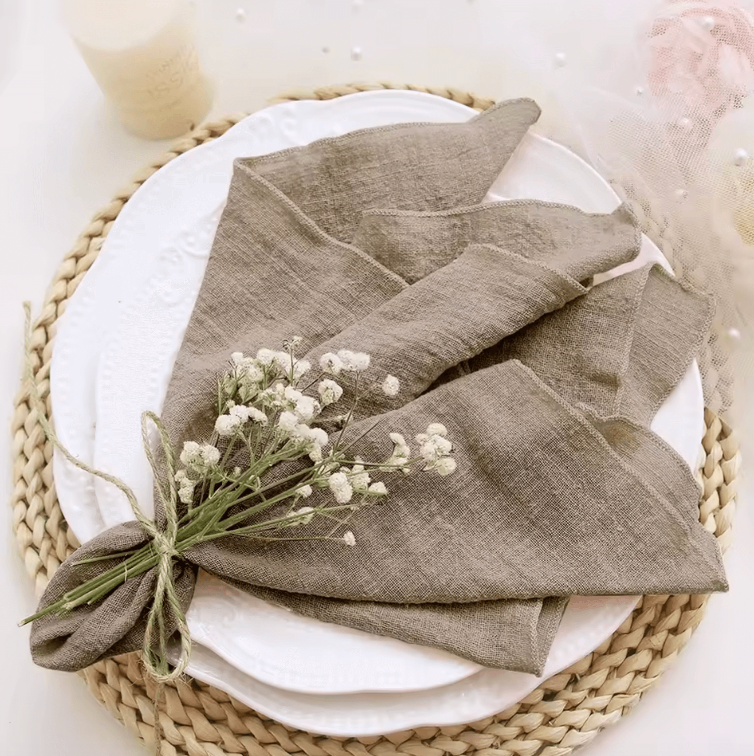 Elegante Baumwoll-Serviette mit Blumenarrangement auf einem gedeckten Tisch.