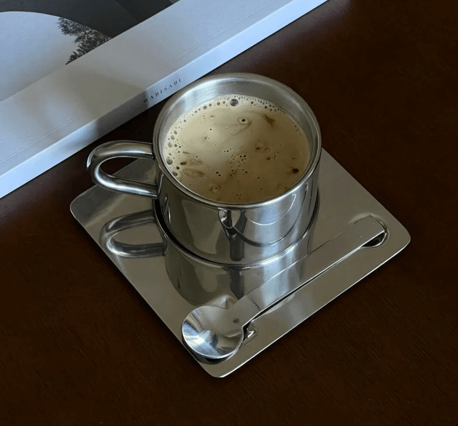 Edelstahl-Kaffeeset eckig mit doppelwandigem Design auf einem Tisch, inklusive Löffel, für stilvollen Kaffeegenuss.