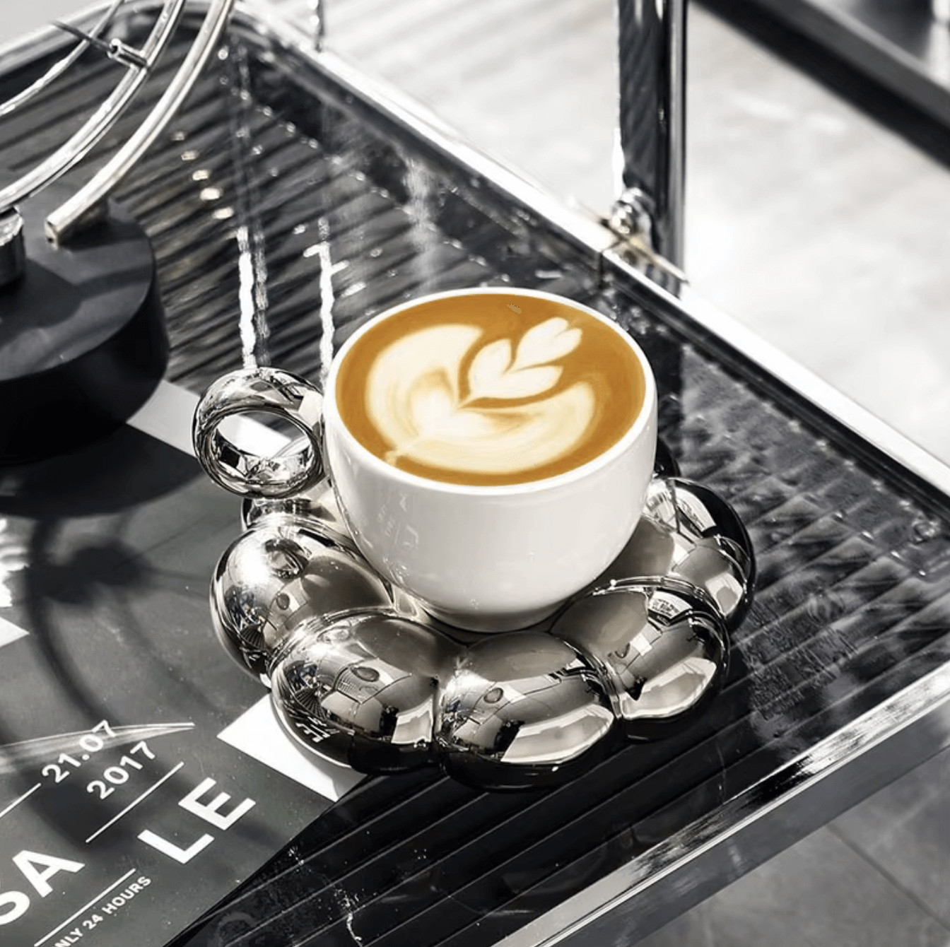 Nordic Elegance ceramic coffee cup on reflective silver coaster with latte art