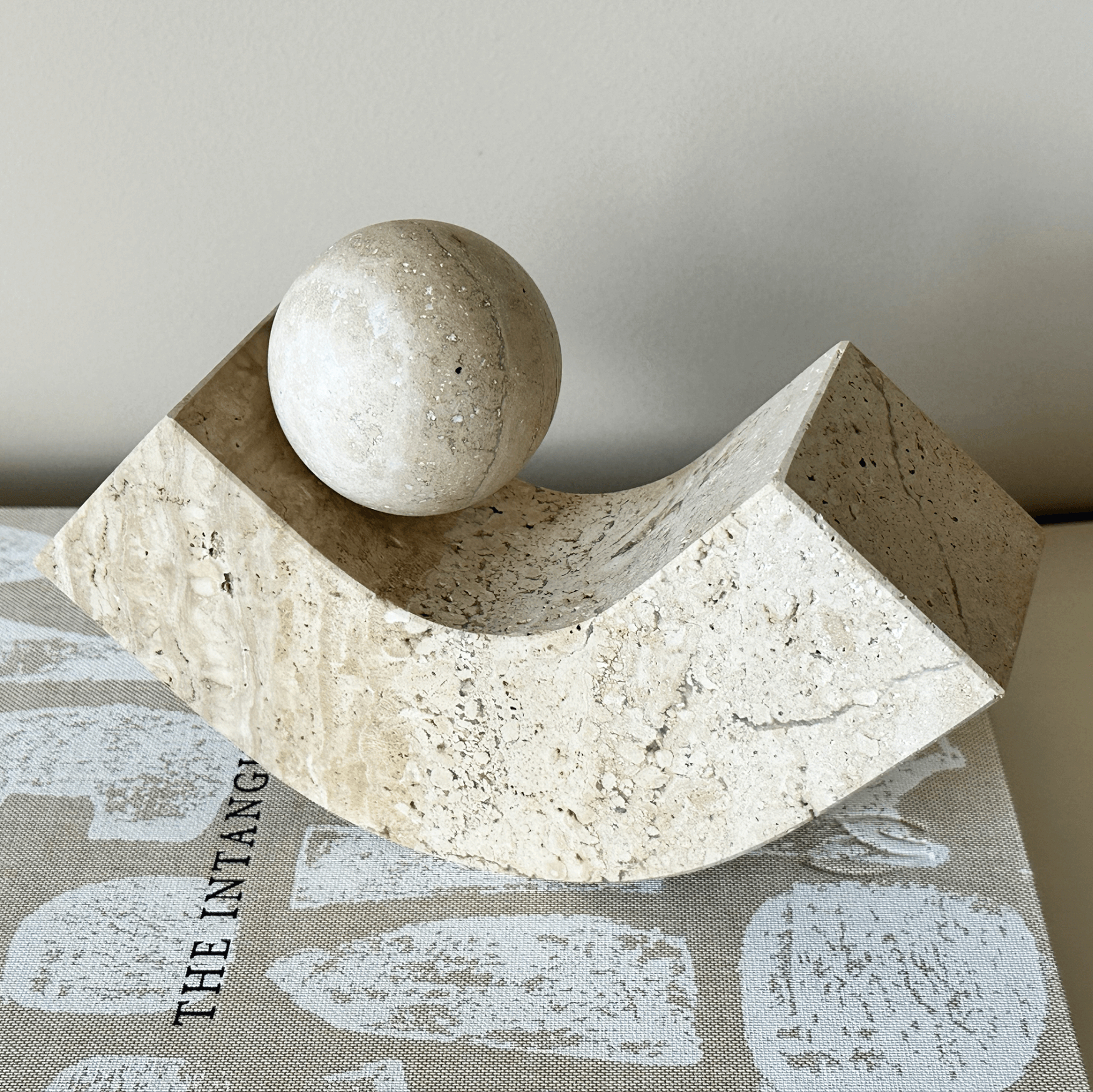 Geometrische Buchstütze aus Naturstein, modernes Design, elegante Ästhetik, handgefertigt, minimalistisch, dekorativ für Büro oder Zuhause.