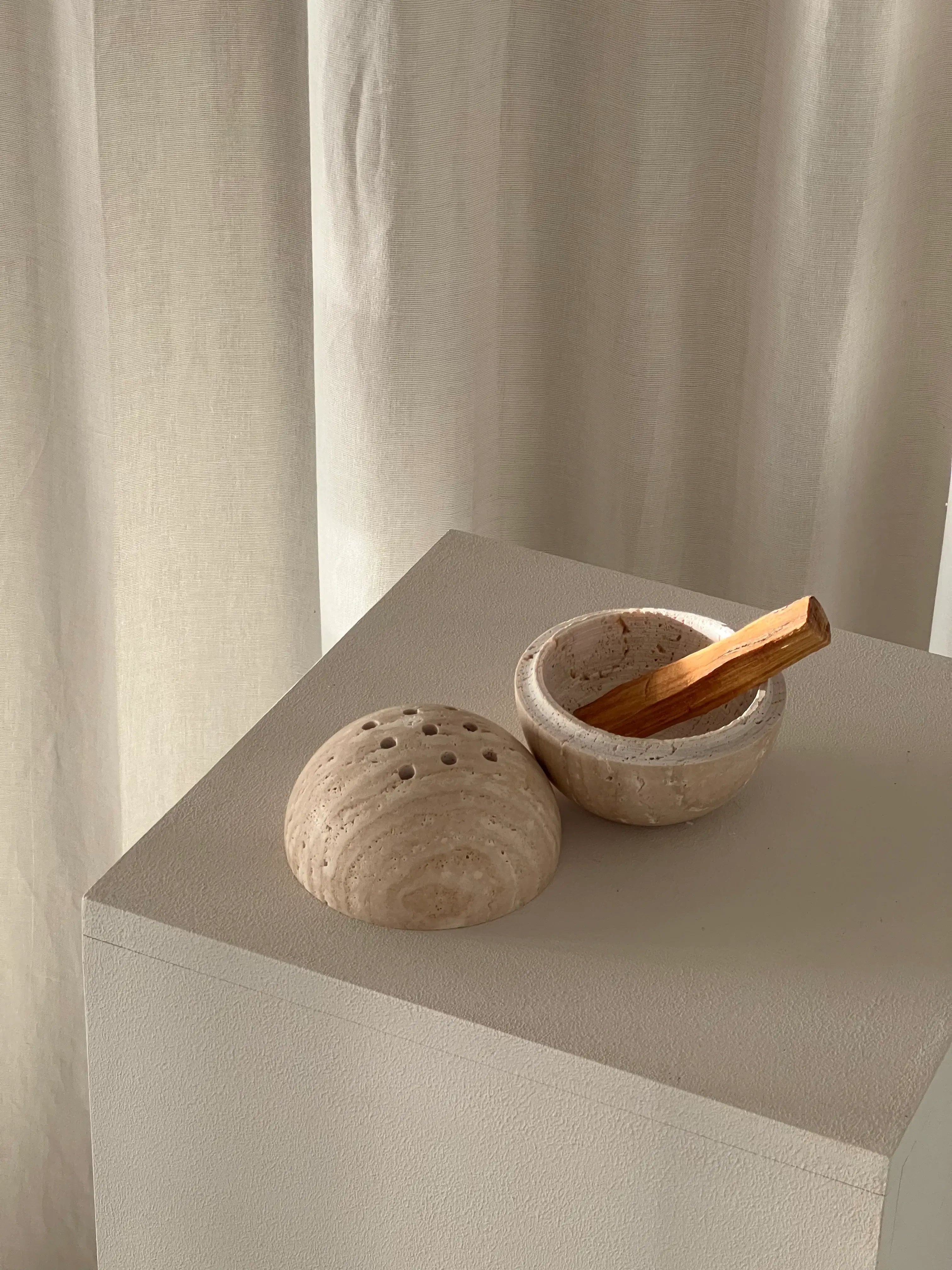 Handcrafted marble incense burner with Palo Santo, displayed on a minimalist pedestal for ritual and wellness ambiance.