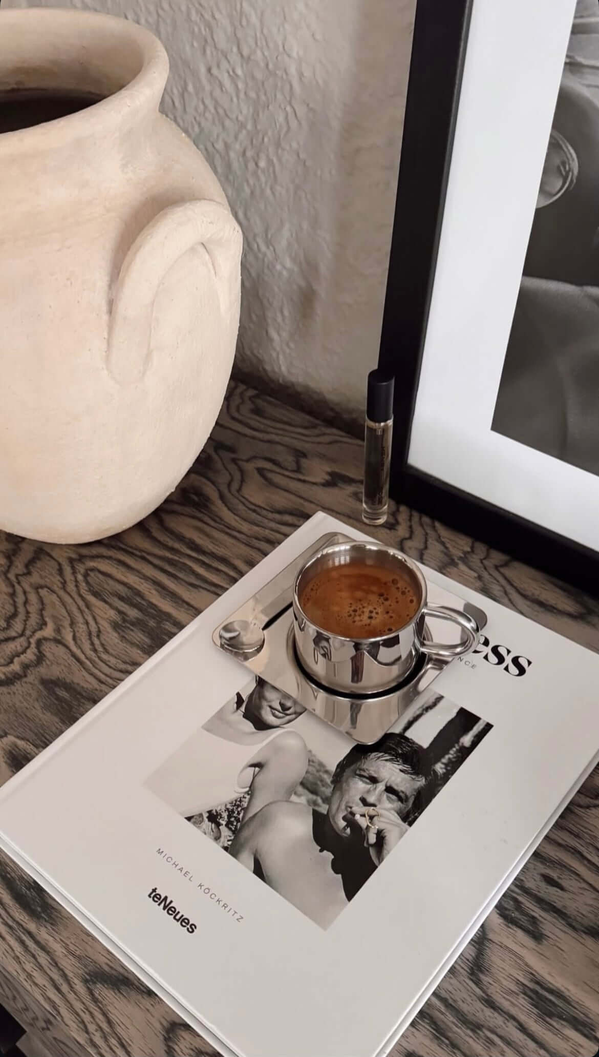 Eckiges Edelstahl-Kaffeeset mit doppelschichtiger Tasse auf Zeitschrift, stilvolles Design für heißen Genuss.
