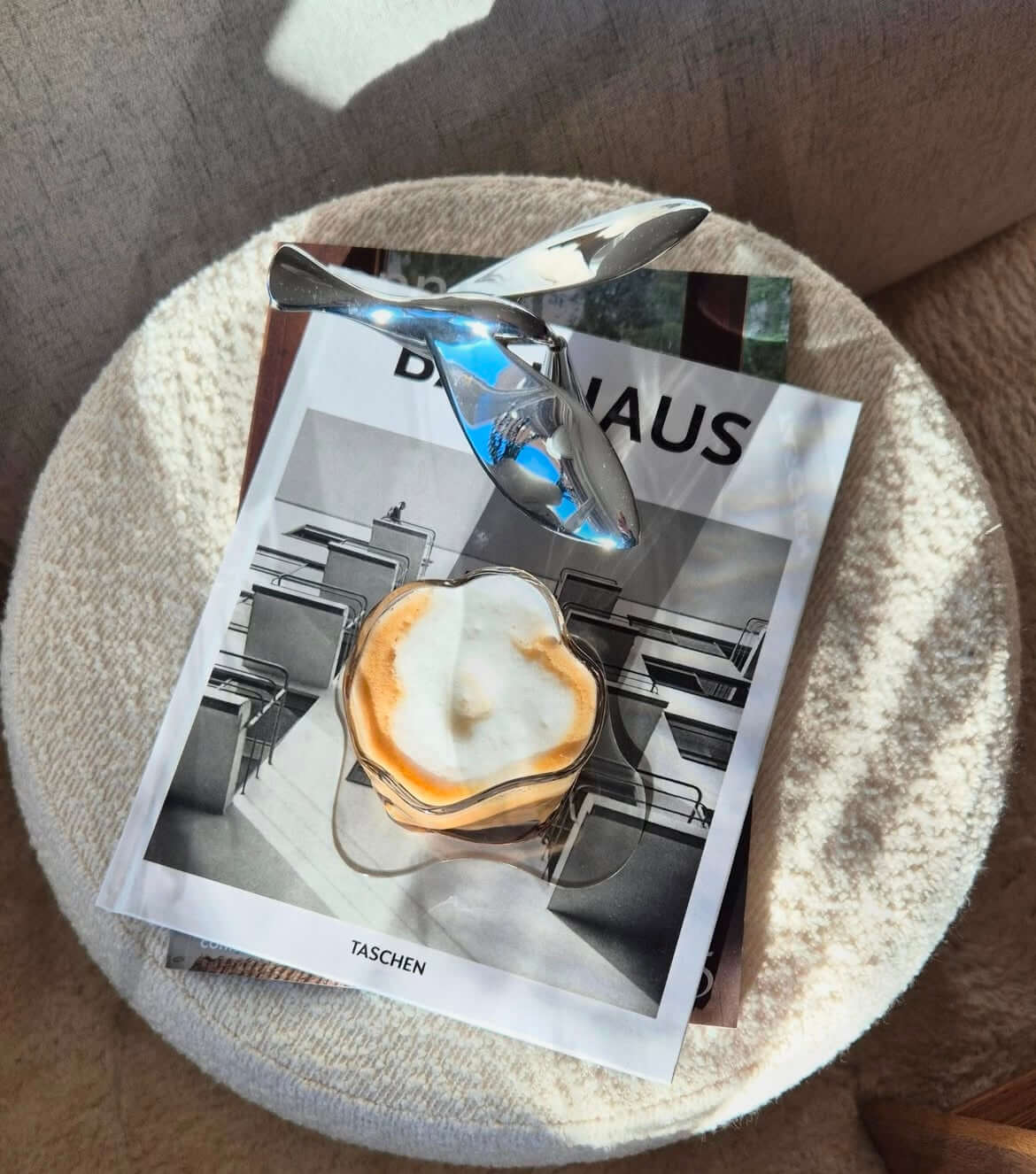 Metallic bird bottle opener with balance effect on book, modern design.